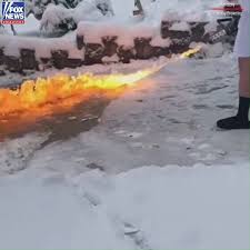 火炎放射器で除雪する男性