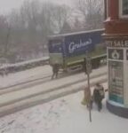 雪道で立ち往生する乳製品配達トラックを押して手伝った女性